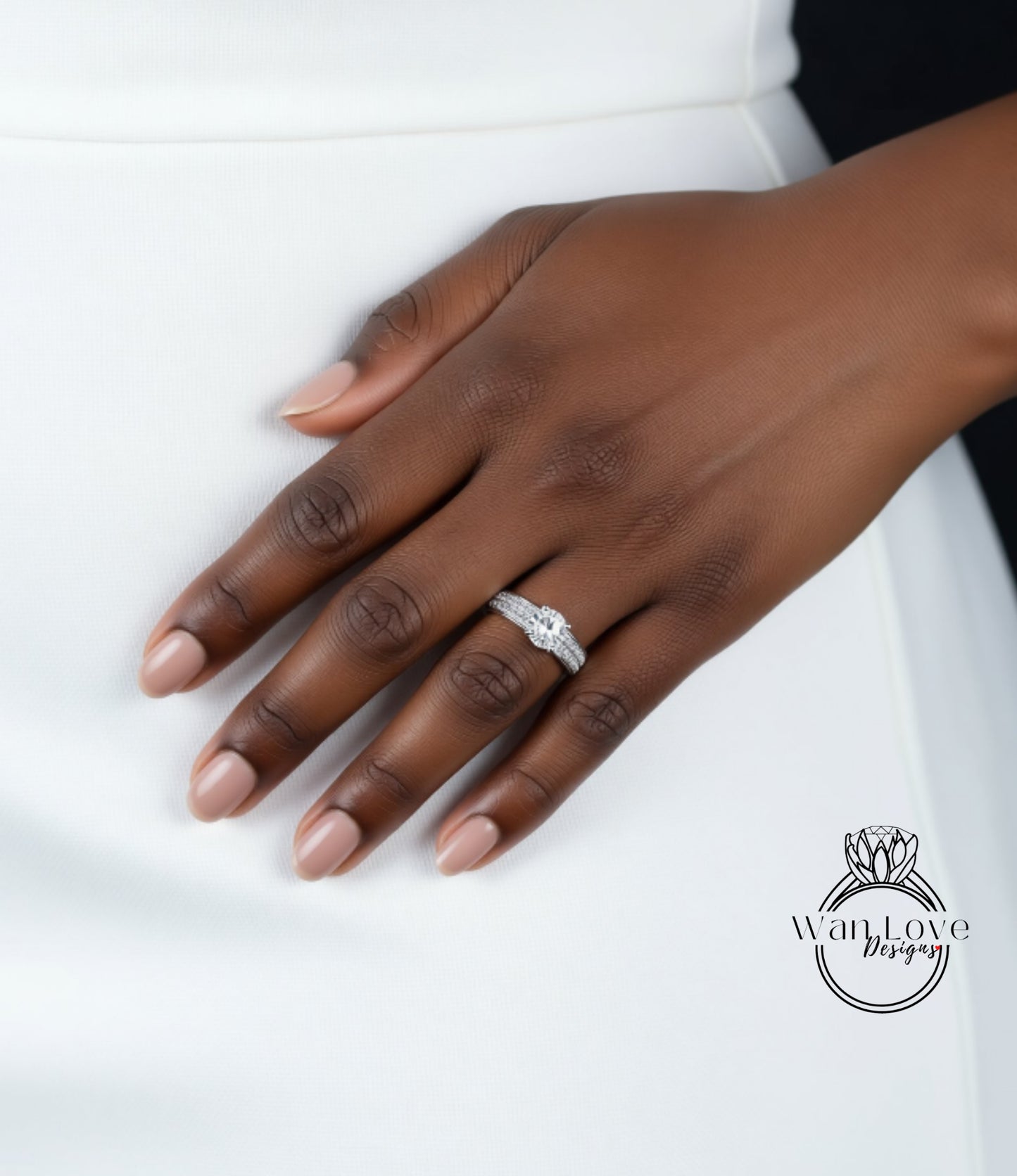 A close-up of a hand wearing a diamond engagement ring.
