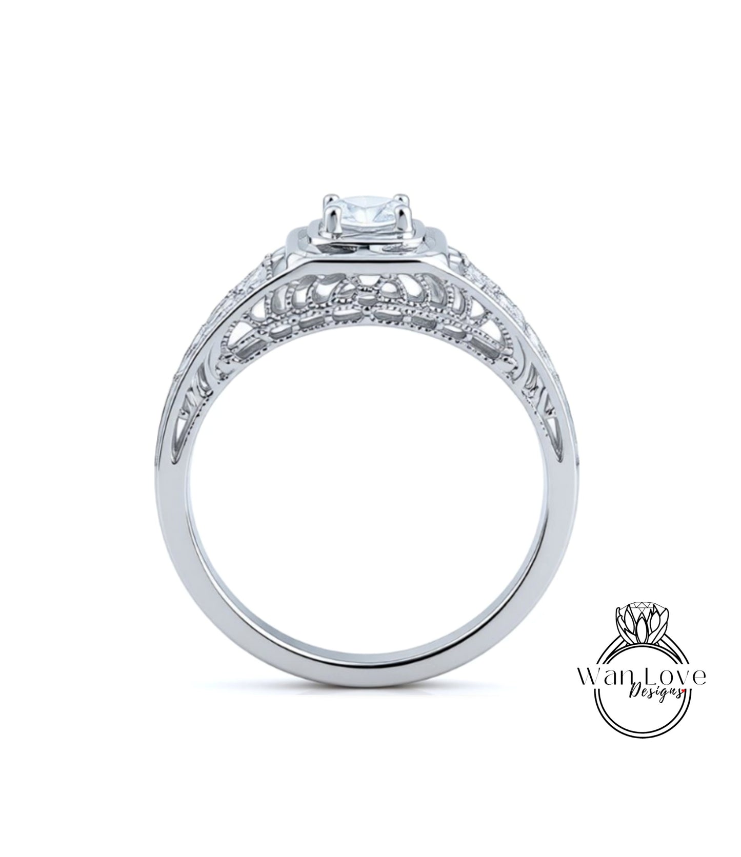 A close-up view of a silver engagement ring with a large central diamond and intricate metalwork detailing.