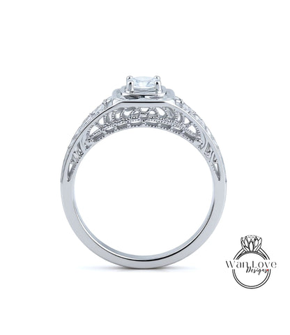 A close-up view of a silver engagement ring with a large central diamond and intricate metalwork detailing.