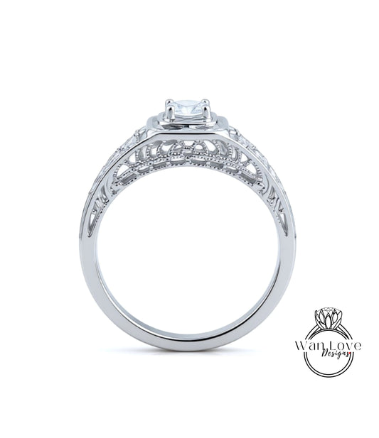 A close-up view of a silver engagement ring with a large central diamond and intricate metalwork detailing.