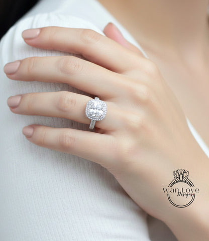 A close-up of a person's hand wearing a large, sparkling diamond ring on the ring finger.