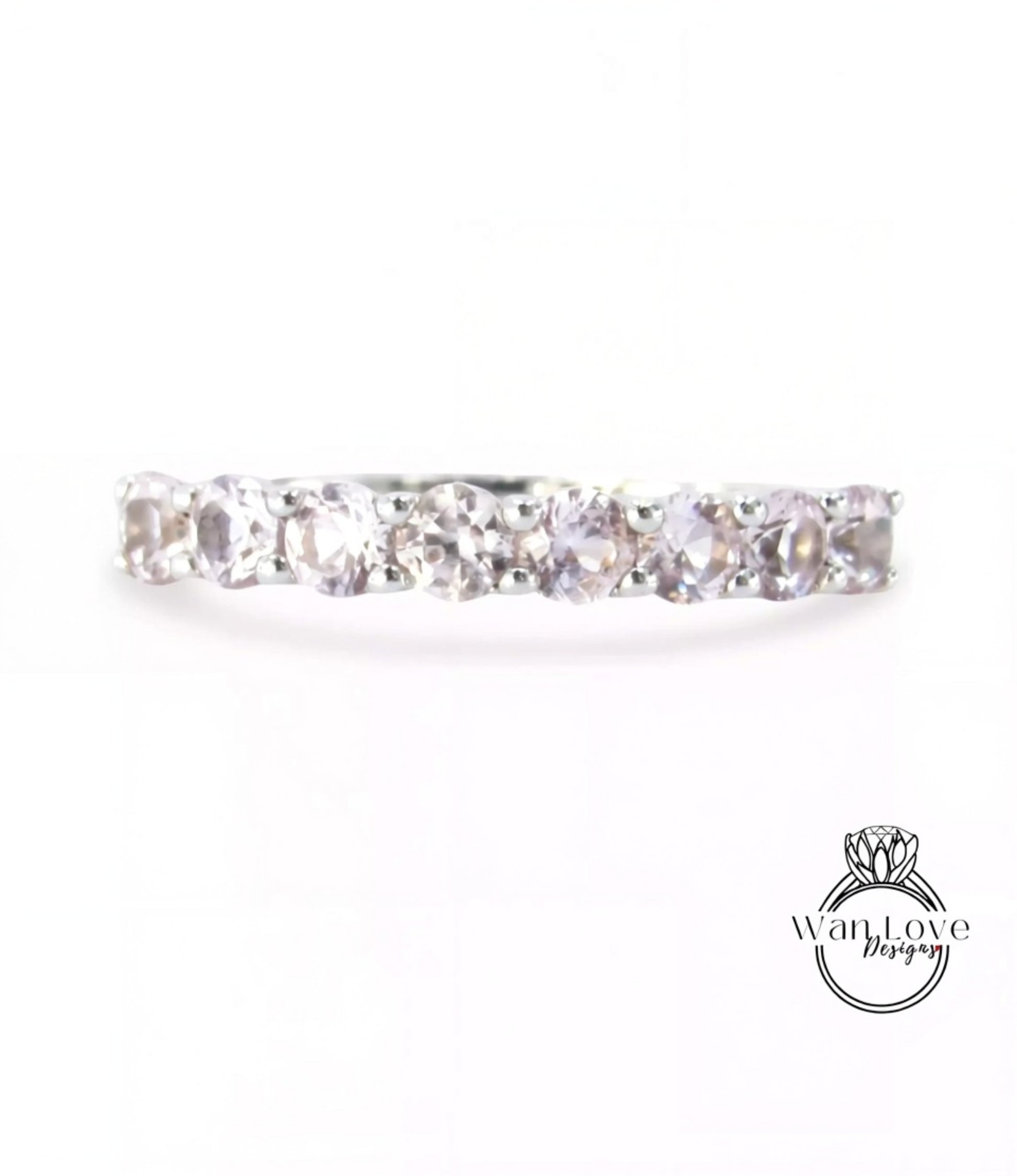 A silver ring with a row of clear gemstones, including diamonds, set in a band.