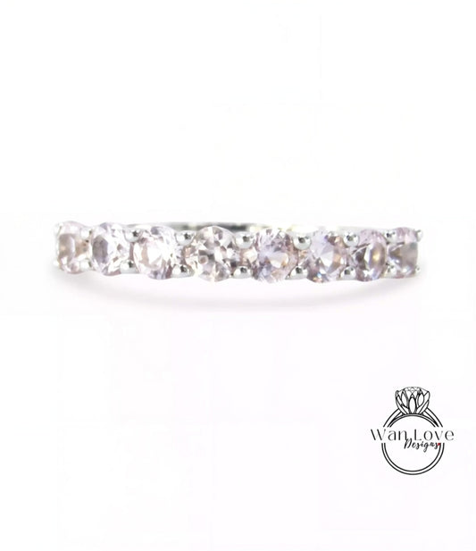 A silver ring with a row of clear gemstones, including diamonds, set in a band.