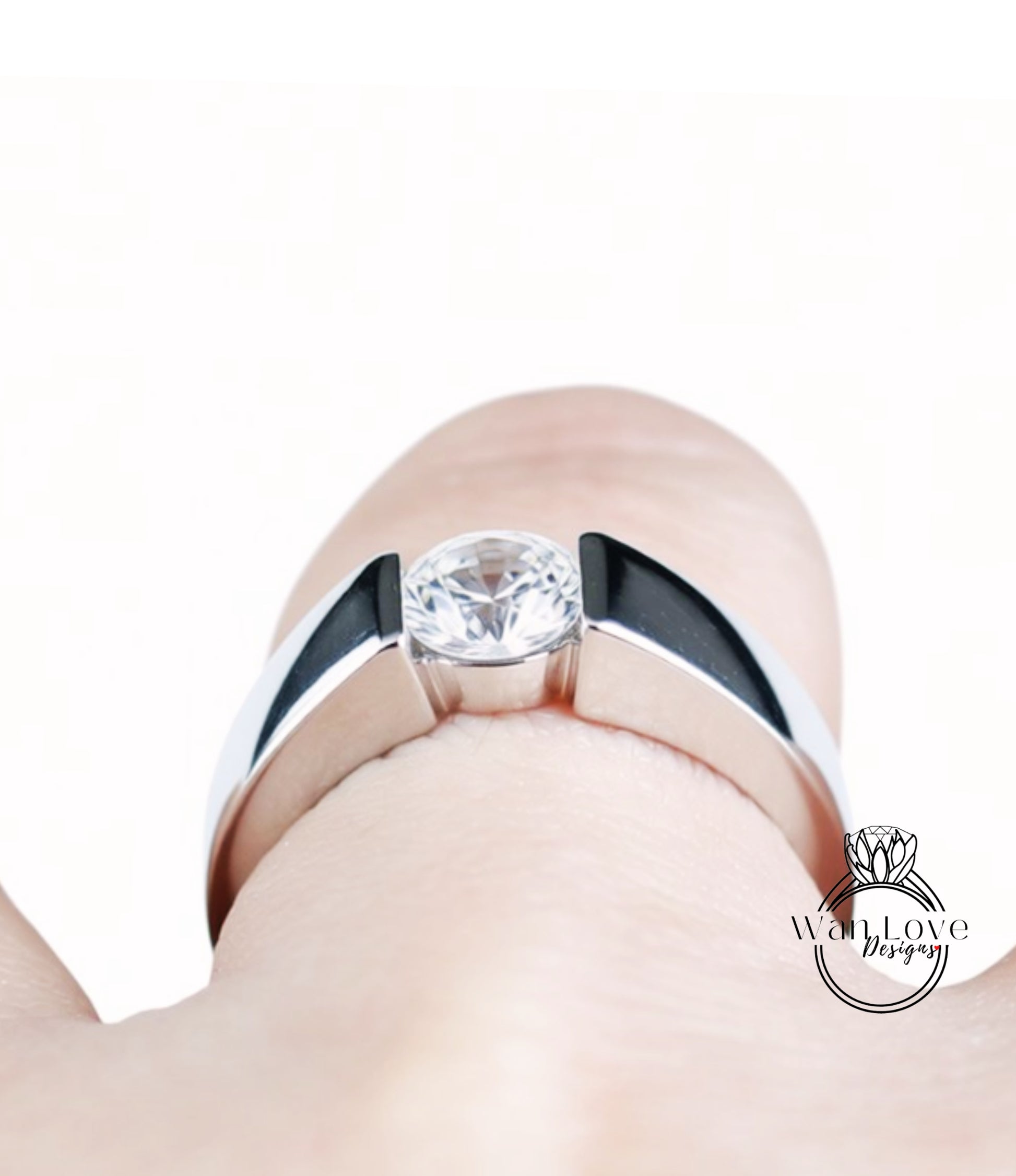 A close-up view of a person's hand wearing a silver ring with a large, clear gemstone.