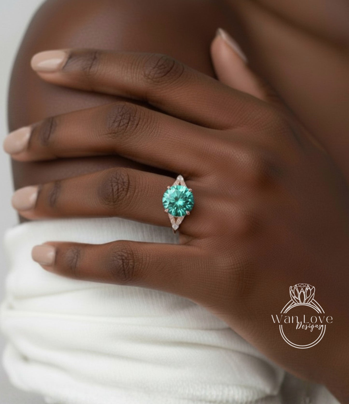 A close-up of a person's hand wearing a ring with a large, green gemstone.