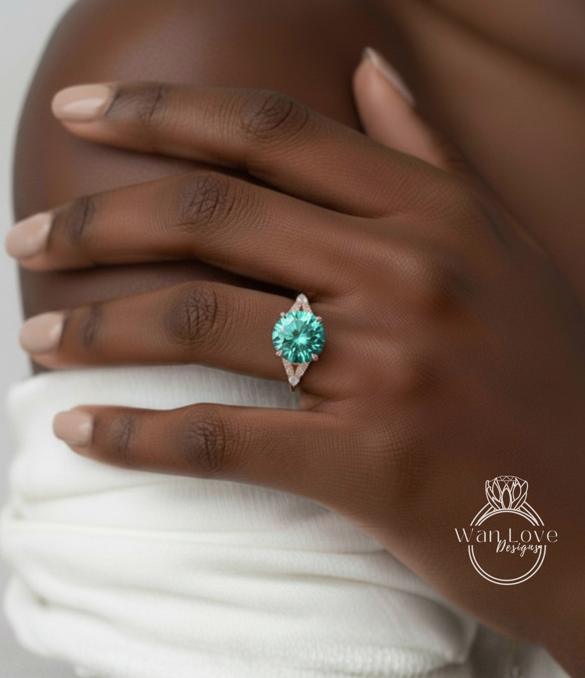 A close-up of a person's hand wearing a ring with a large, green gemstone.