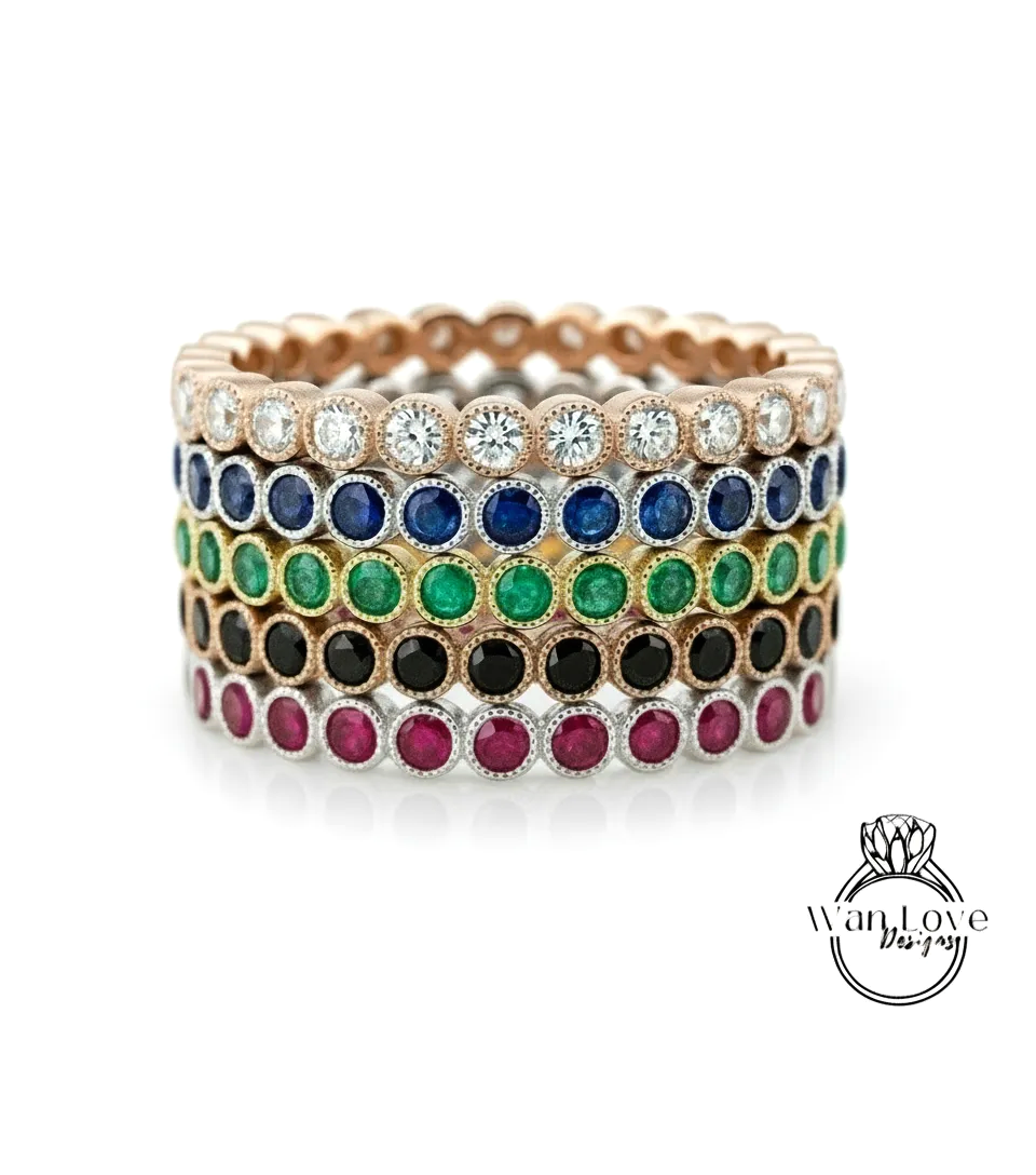 A stack of colorful rings with various gemstones, including diamonds and colored stones, set in a gold or silver band.
