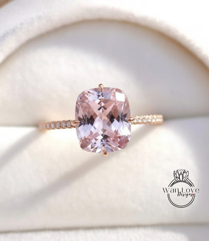 A close-up image of a gold ring with a large, pink gemstone set in the center.