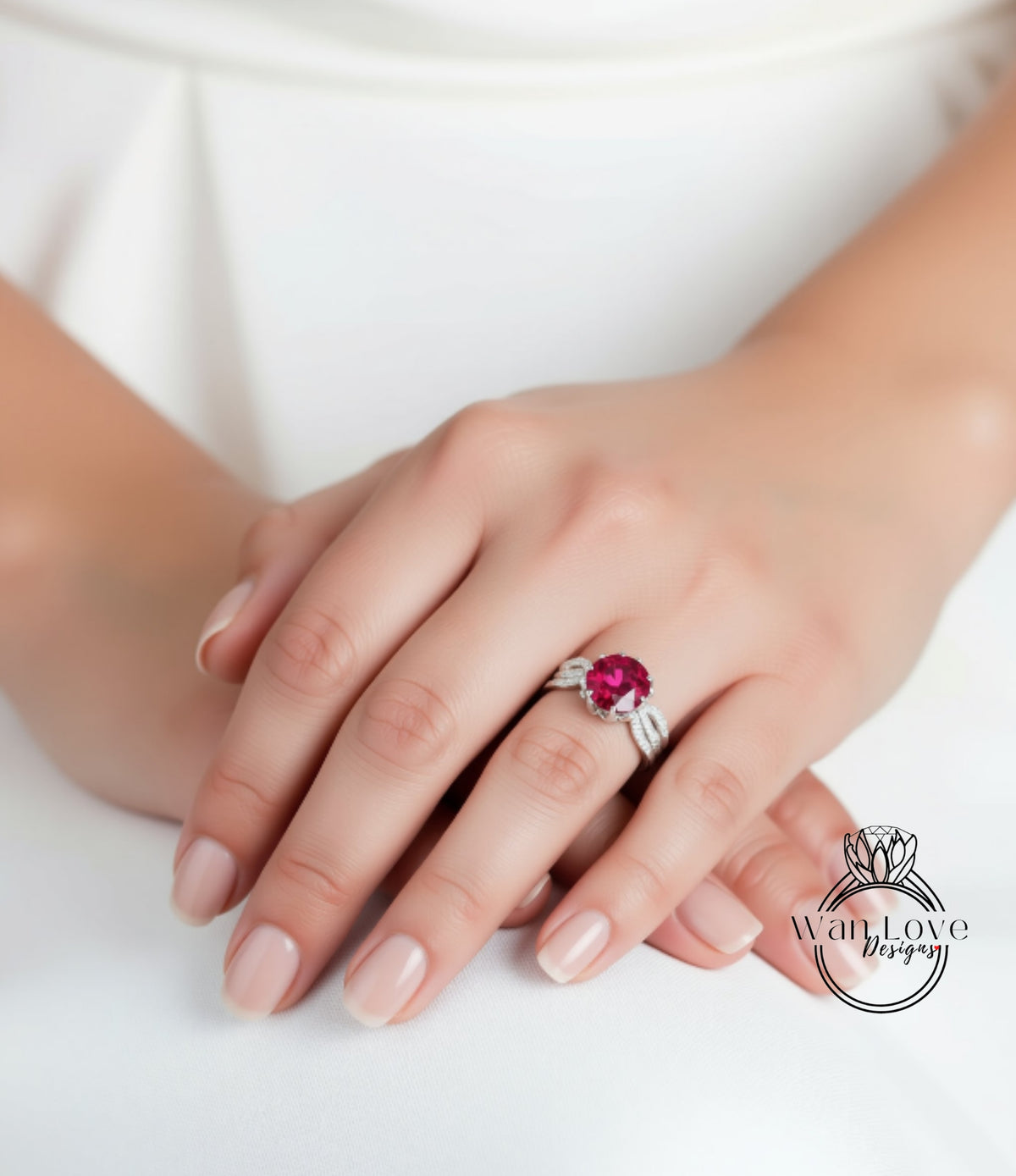 A close-up of a person's hand wearing a ring with a large, vibrant red gemstone.