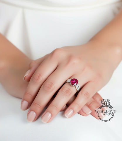 A close-up of a person's hand wearing a ring with a large, vibrant red gemstone.