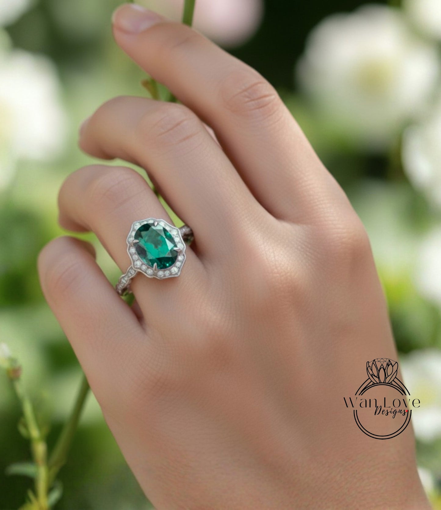 A close-up of a hand wearing a ring with a large oval-shaped gemstone, likely an emerald, set in a halo of smaller diamonds.