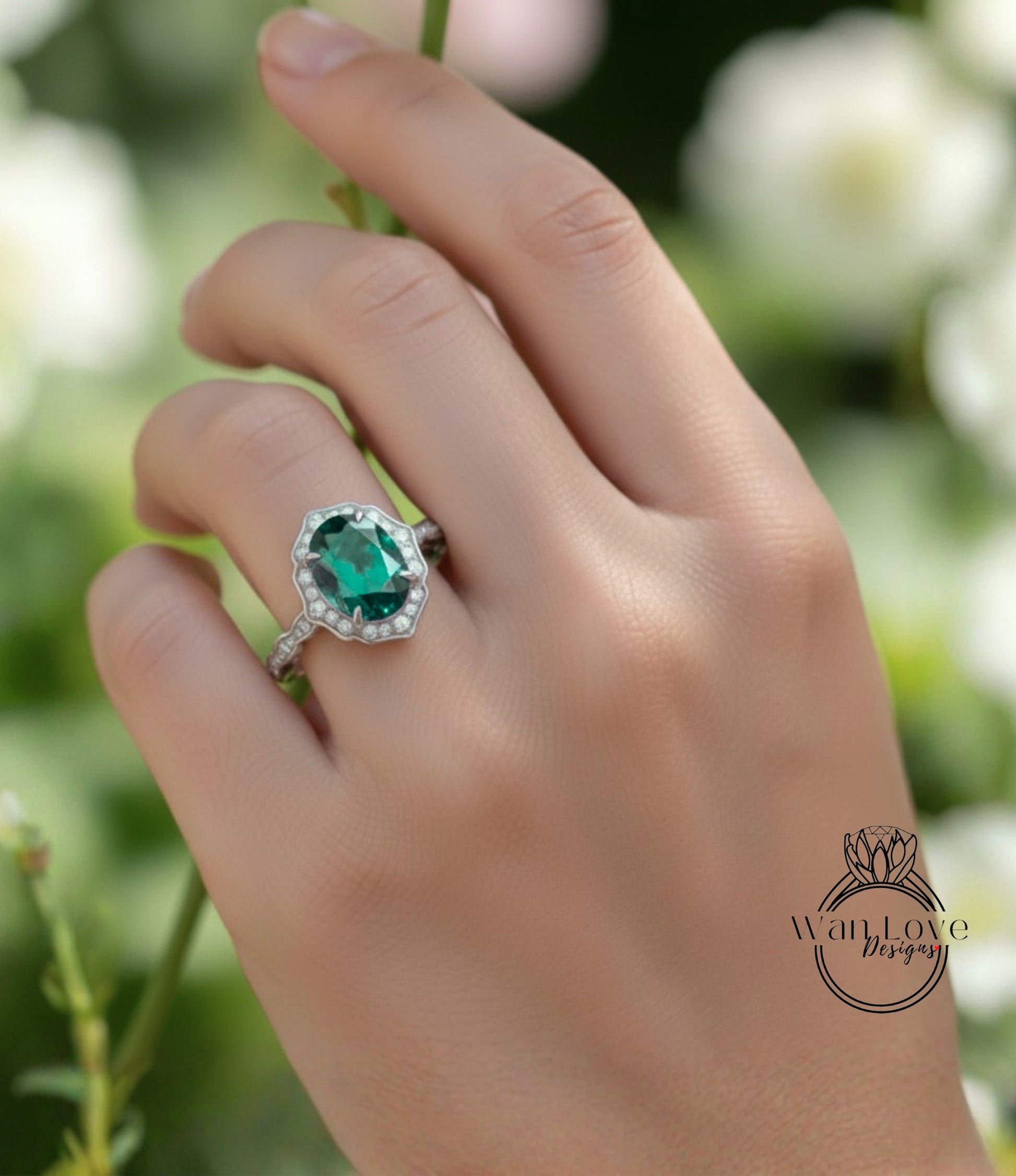A close-up of a hand wearing a ring with a large oval-shaped gemstone, likely an emerald, set in a halo of smaller diamonds.