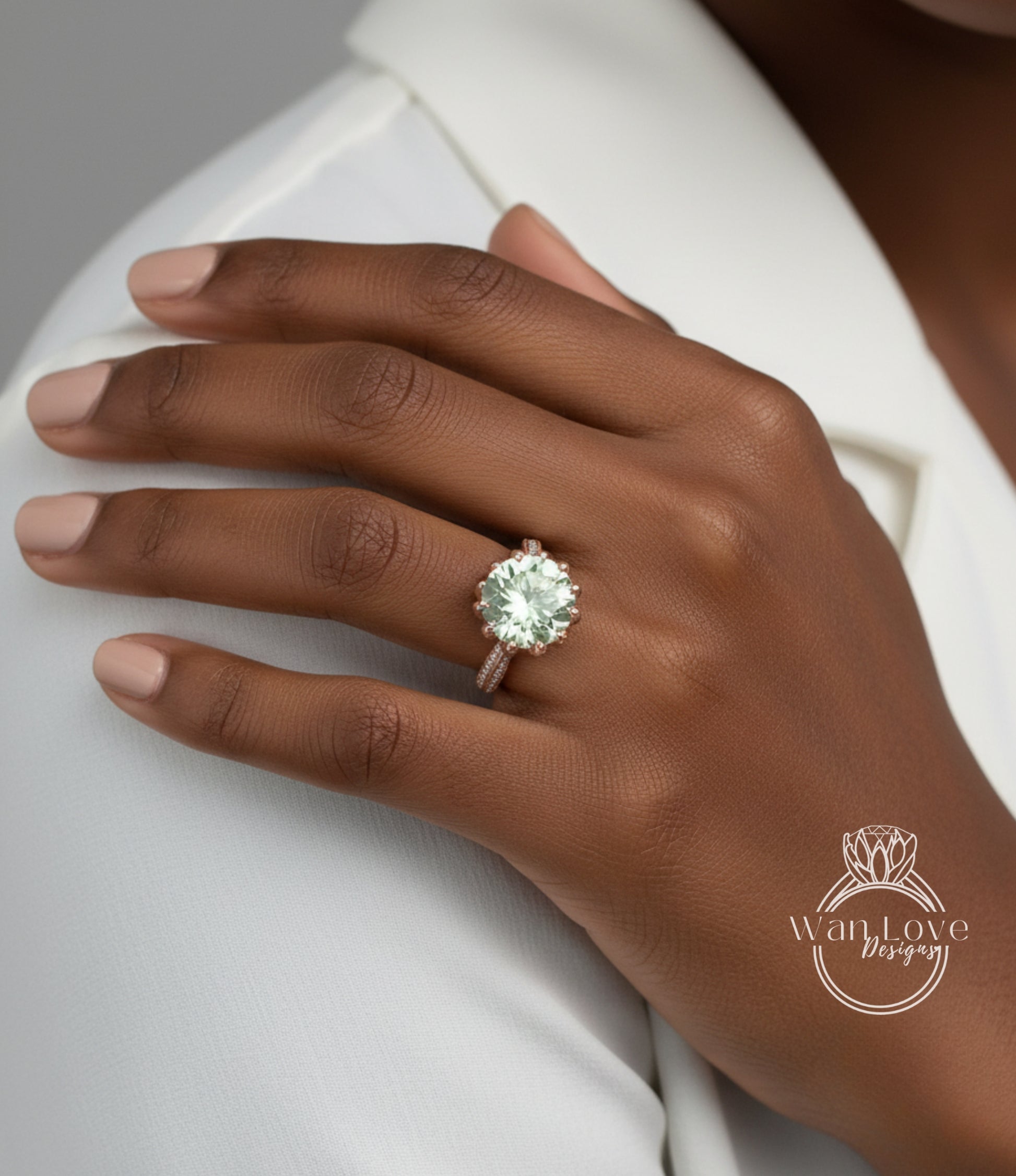 A close-up of a person's hand wearing a large, greenish-green gemstone ring on the ring finger.