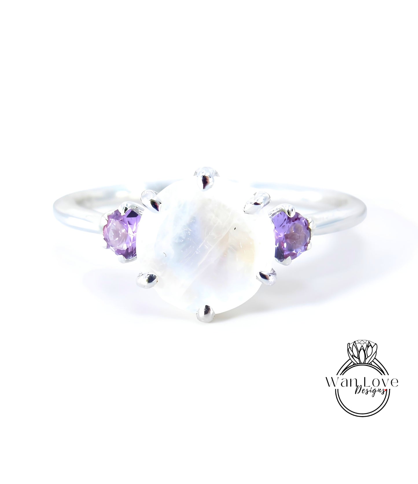 A silver ring with a large moonstone and two purple gemstones on either side.