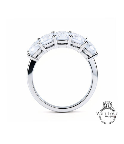 A silver ring with a row of clear gemstones on the band.