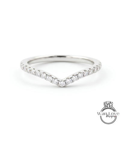 A silver ring with a v-shaped band and a row of small diamonds set in the center.