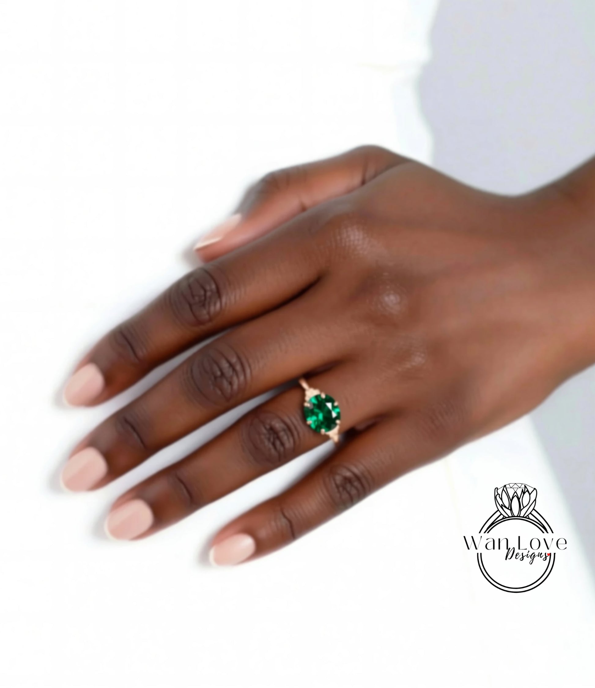 A close-up of a hand wearing a gold ring with a large green gemstone.