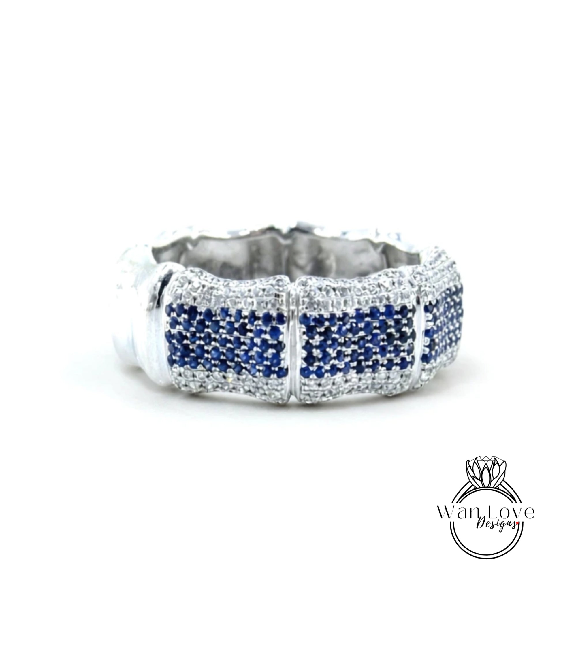 A silver ring with blue gemstones, possibly sapphires, set in a decorative pattern.