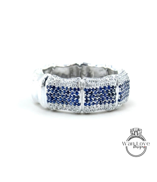 A silver ring with blue gemstones, possibly sapphires, set in a decorative pattern.