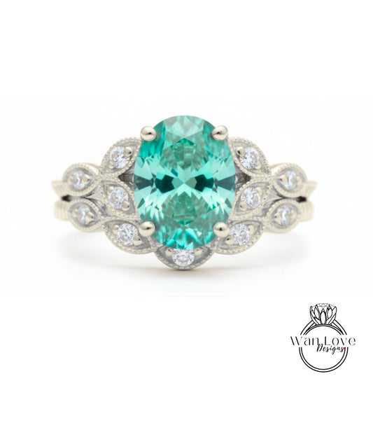 A silver ring with a large oval-shaped gemstone, surrounded by smaller diamonds, set in a decorative band.