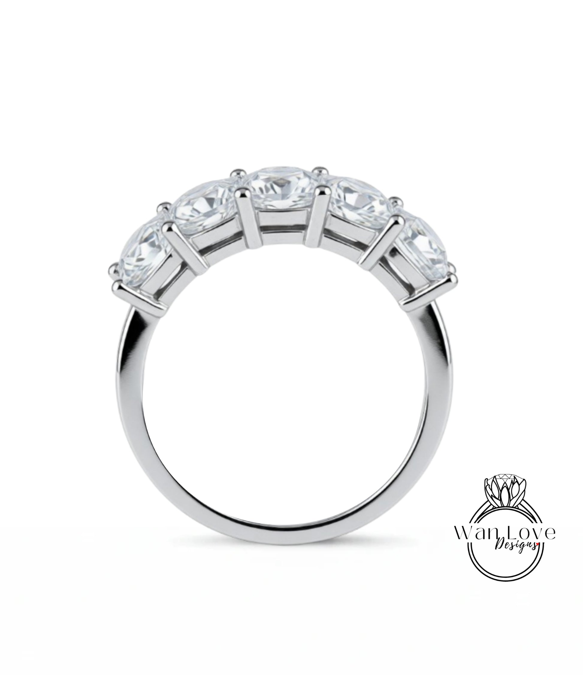 A silver ring with a row of five clear gemstones set in the band.