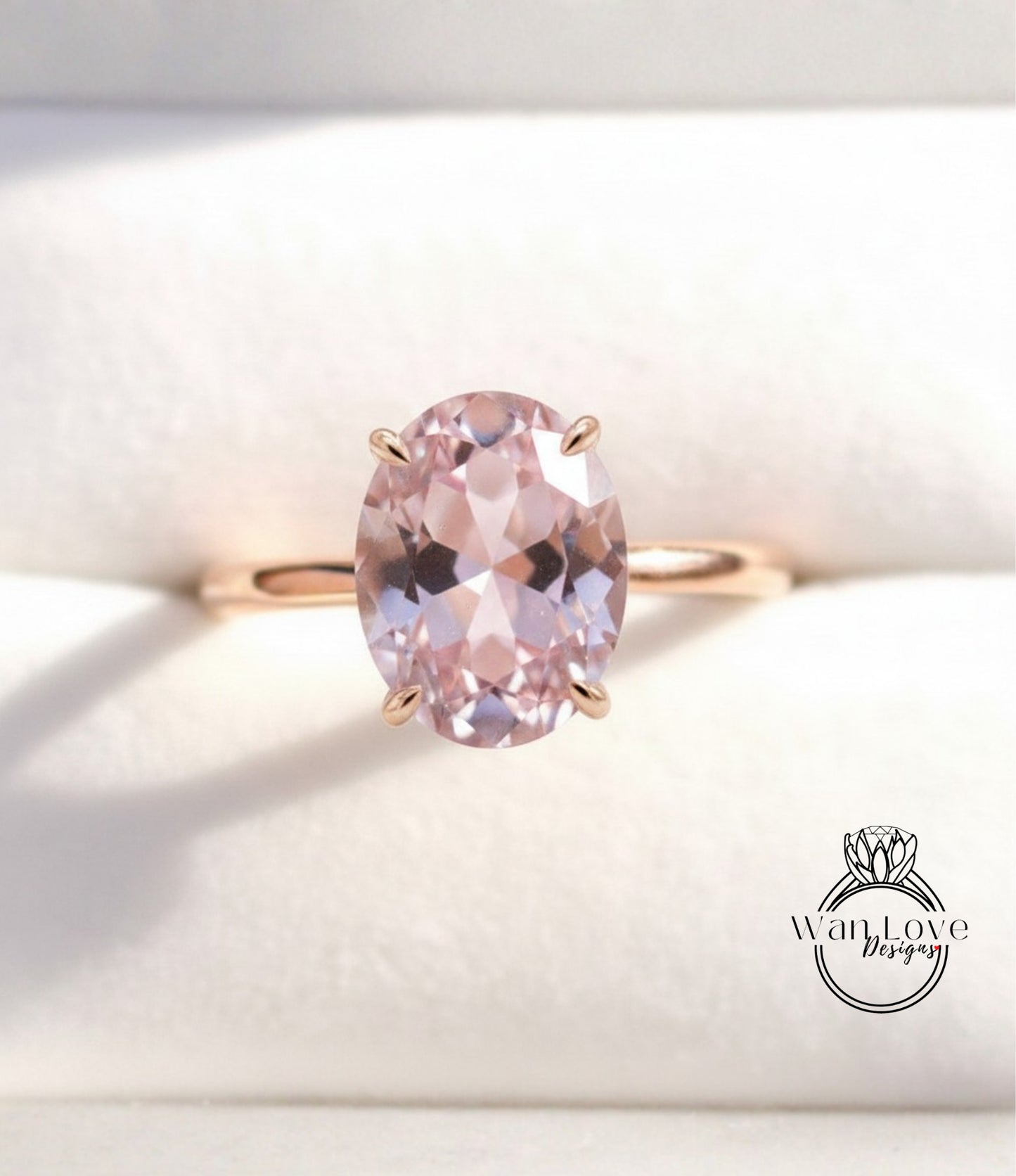 A gold ring with a large oval-shaped pink gemstone set in the center.
