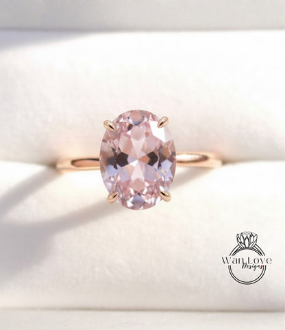 A gold ring with a large oval-shaped pink gemstone set in the center.
