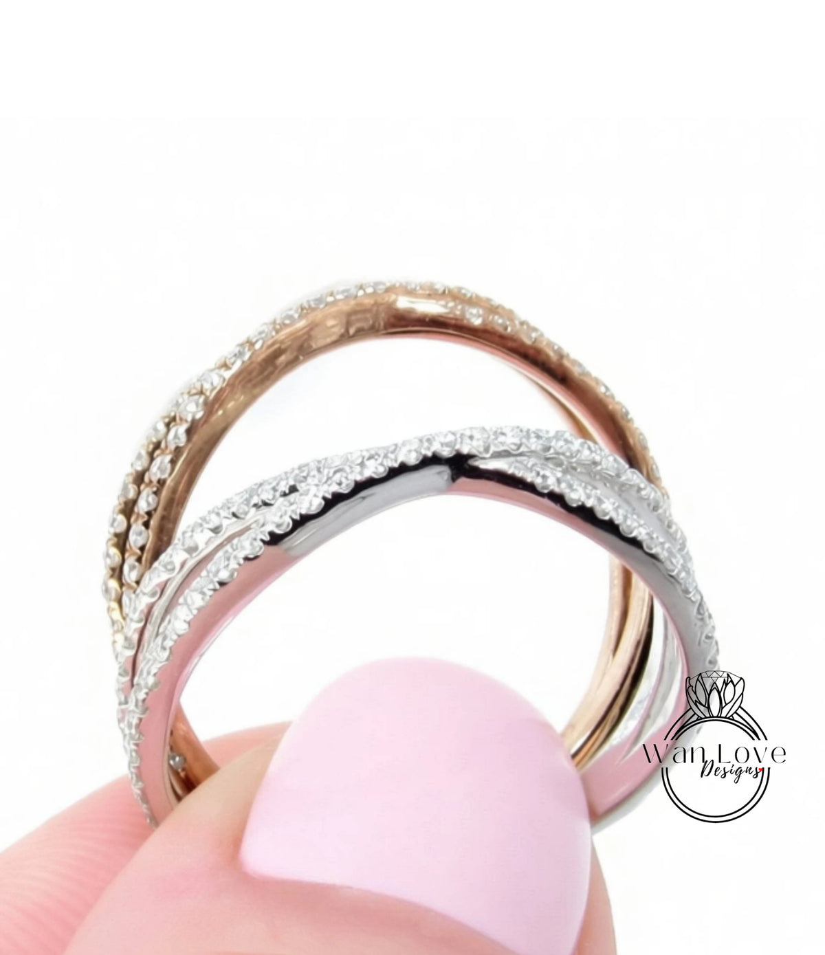 A close-up of a person's hand holding a ring with a combination of silver and gold bands adorned with sparkling diamonds.