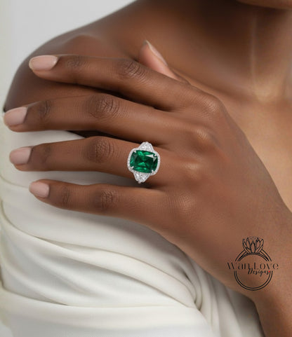 A close-up of a person's hand wearing a large, green gemstone ring with a diamond accent.