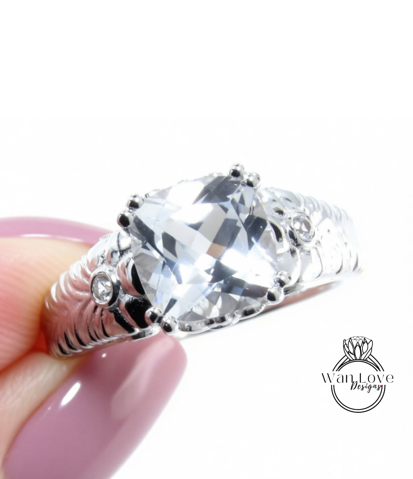 A close-up of a person's hand holding a silver ring with a large, clear gemstone.