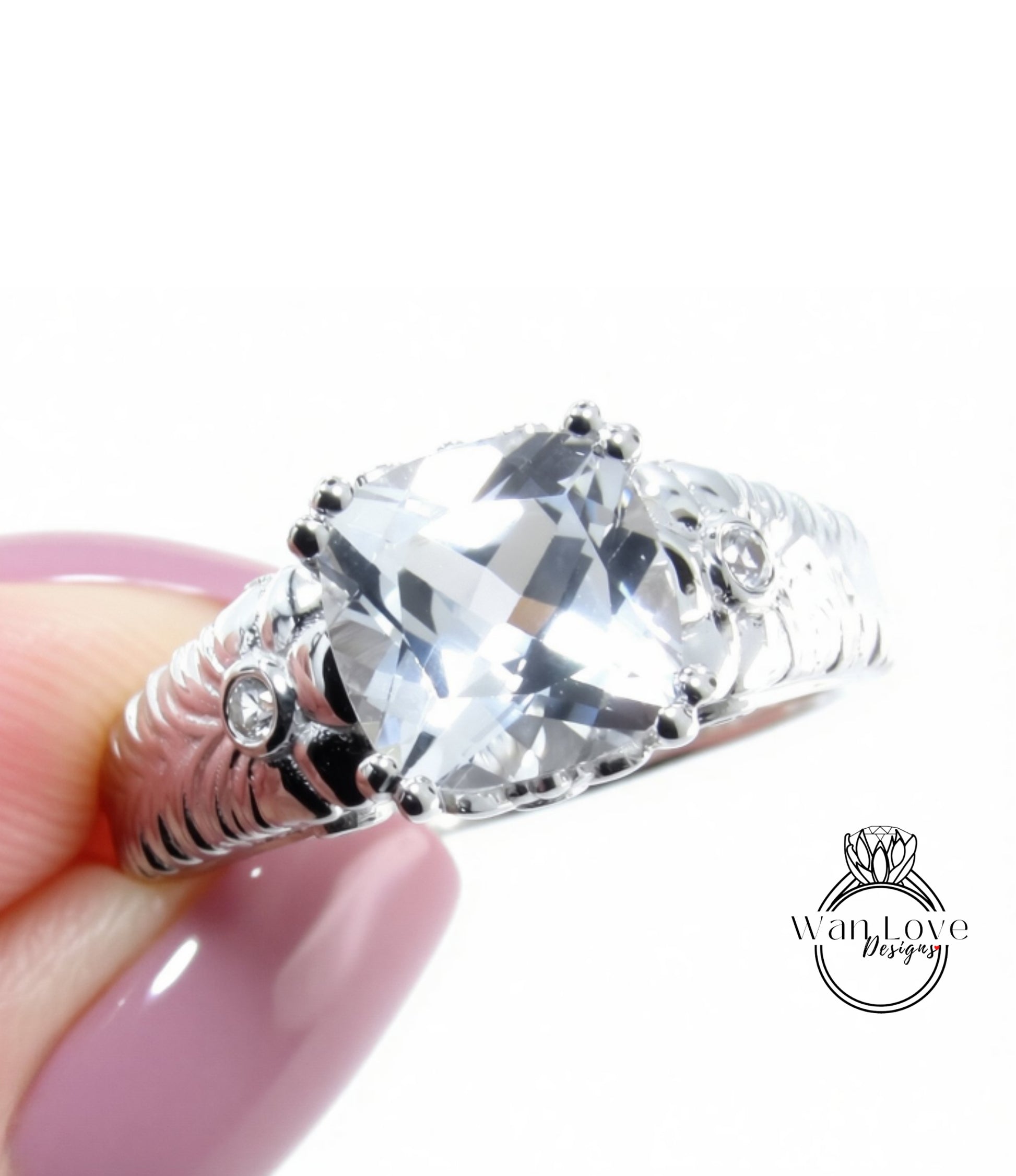 A close-up of a person's hand holding a silver ring with a large, clear gemstone.