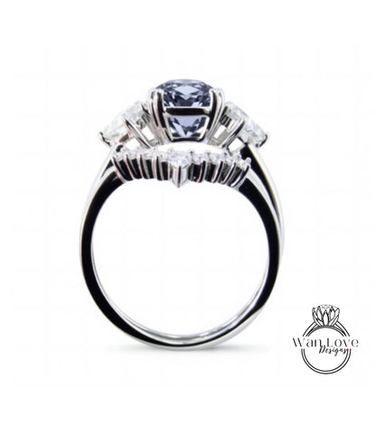 A silver ring with a large blue gemstone, possibly a diamond, set in the center.