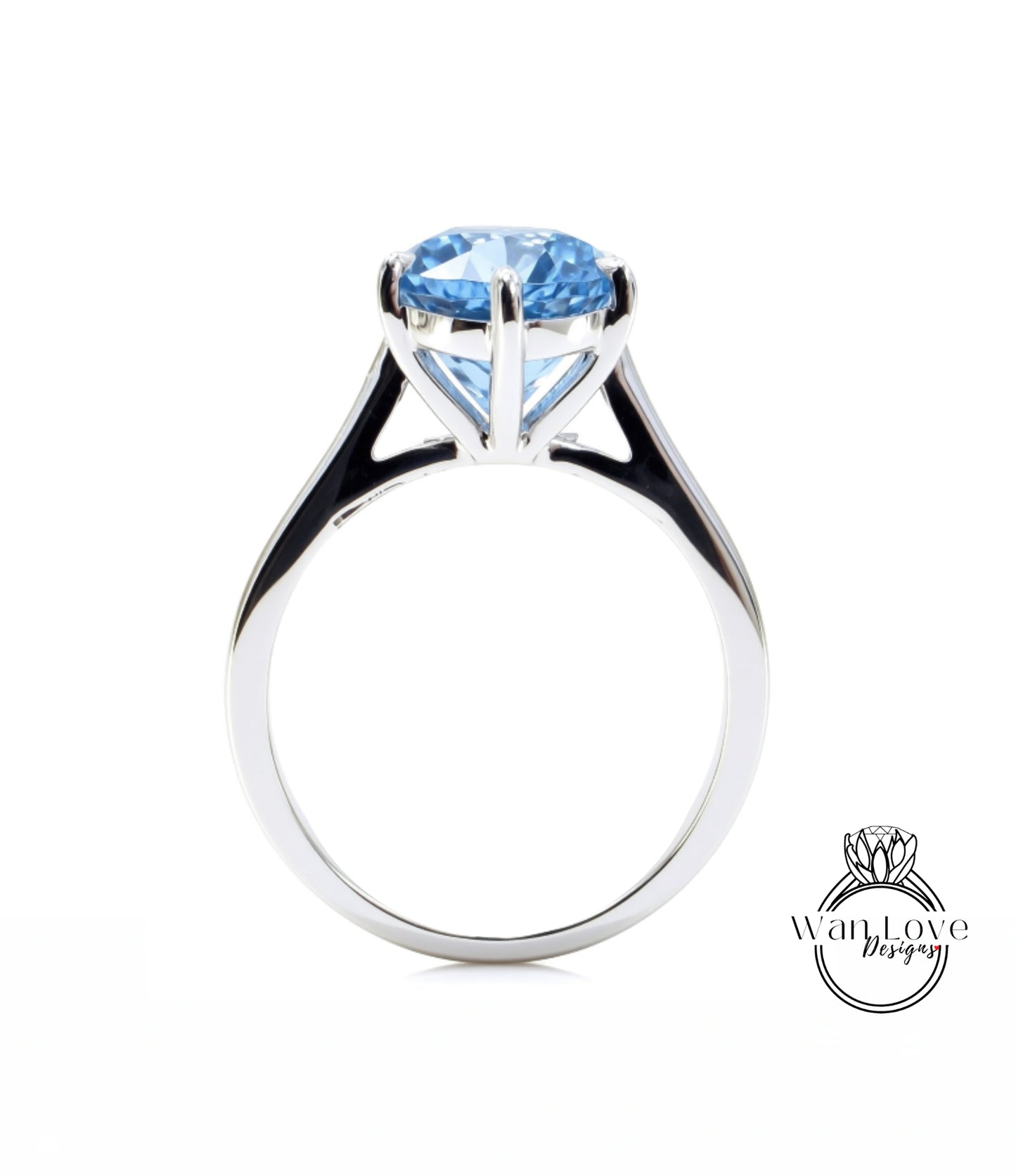A silver ring with a large blue gemstone, likely a diamond, set in the center of the band.