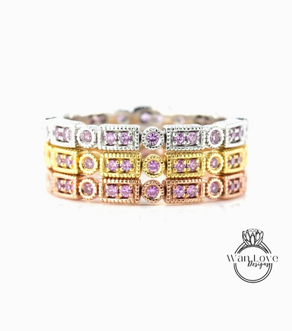 A ring with multiple layers of rings, each ring adorned with a small purple gemstone. The rings are arranged in a circular pattern, creating a visually appealing and intricate design.
