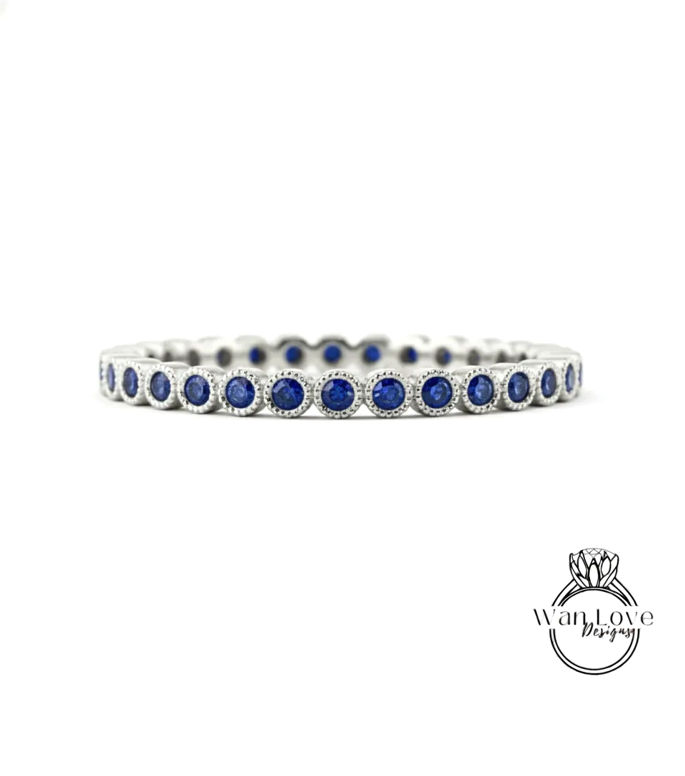 A silver band adorned with blue sapphires, showcasing a row of round gemstones set in a metallic frame.