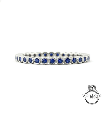 A silver band adorned with blue sapphires, showcasing a row of round gemstones set in a metallic frame.
