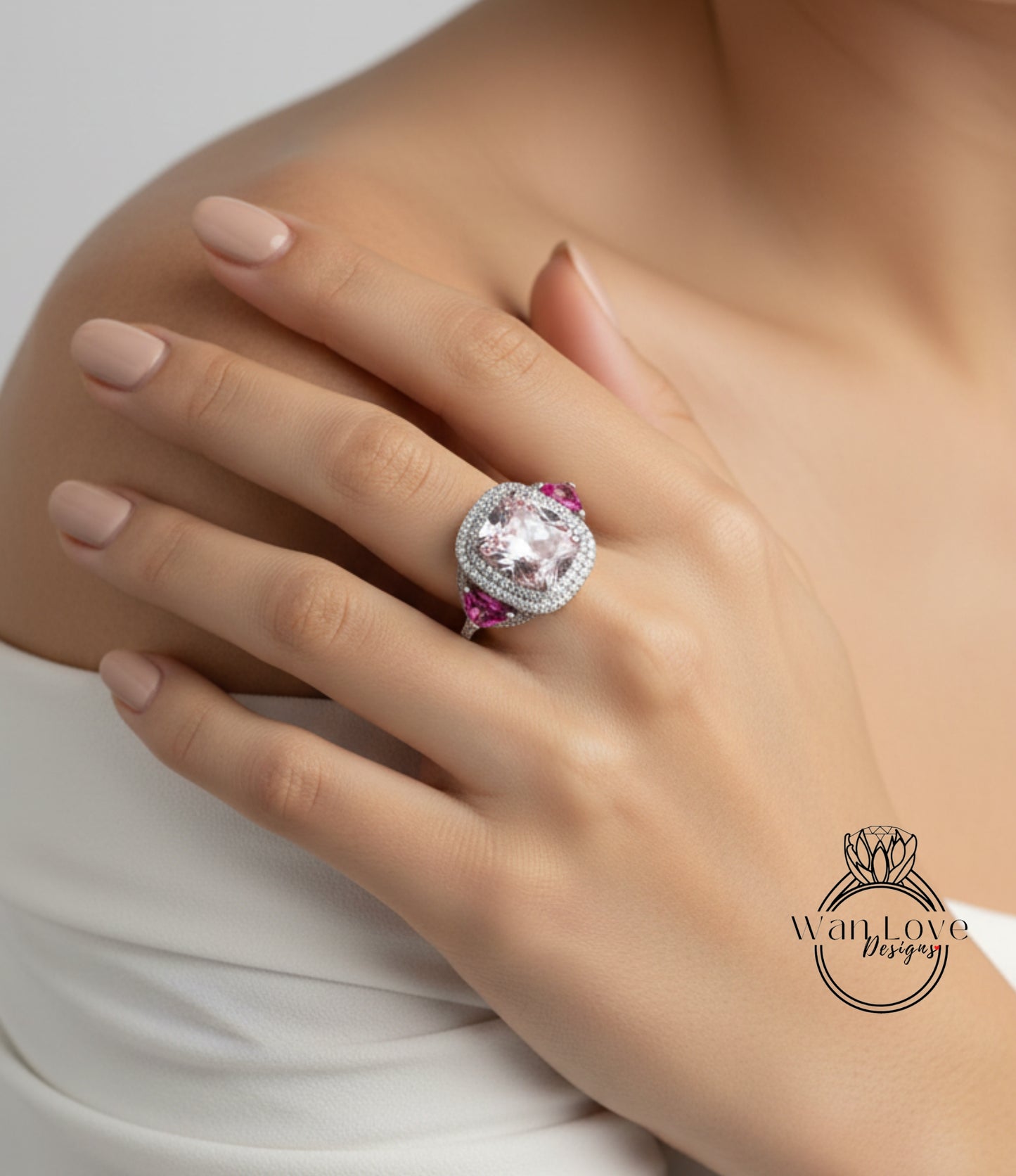 A close-up of a person's hand wearing a large, ornate ring with a pink gemstone.