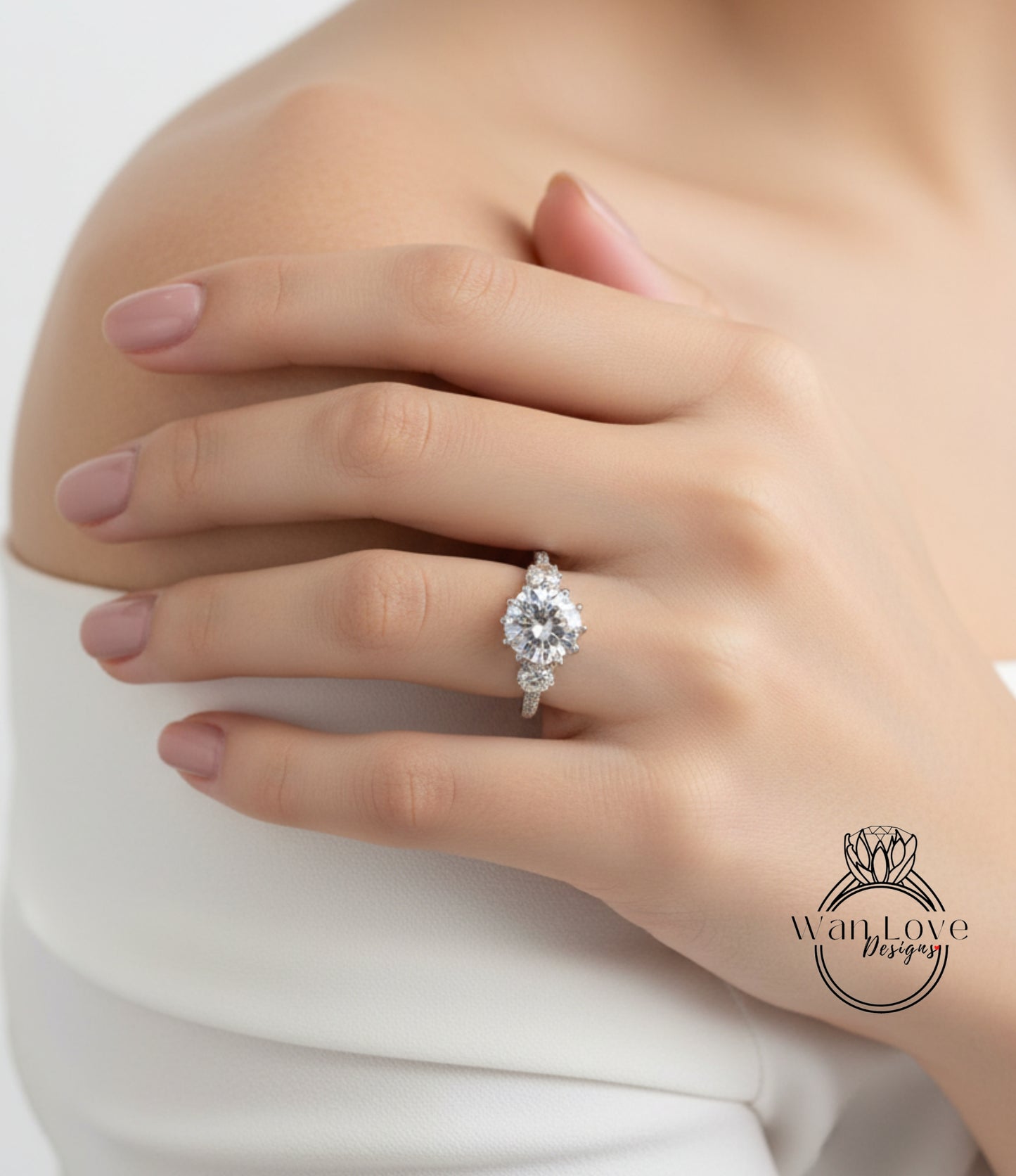 A close-up of a person's hand wearing a diamond engagement ring on the ring finger.