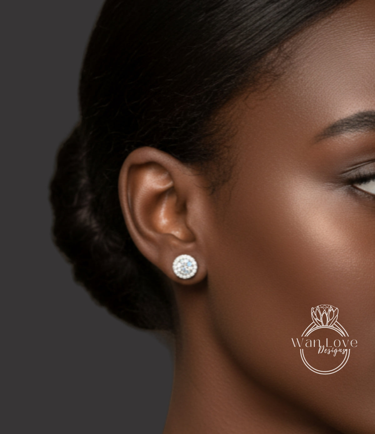 A close-up of a woman's ear with a diamond earring, against a dark background.