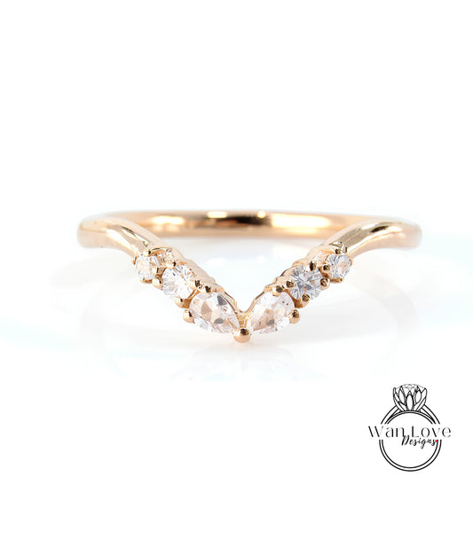 A gold ring with a v-shaped band and a row of small diamonds set in the center.