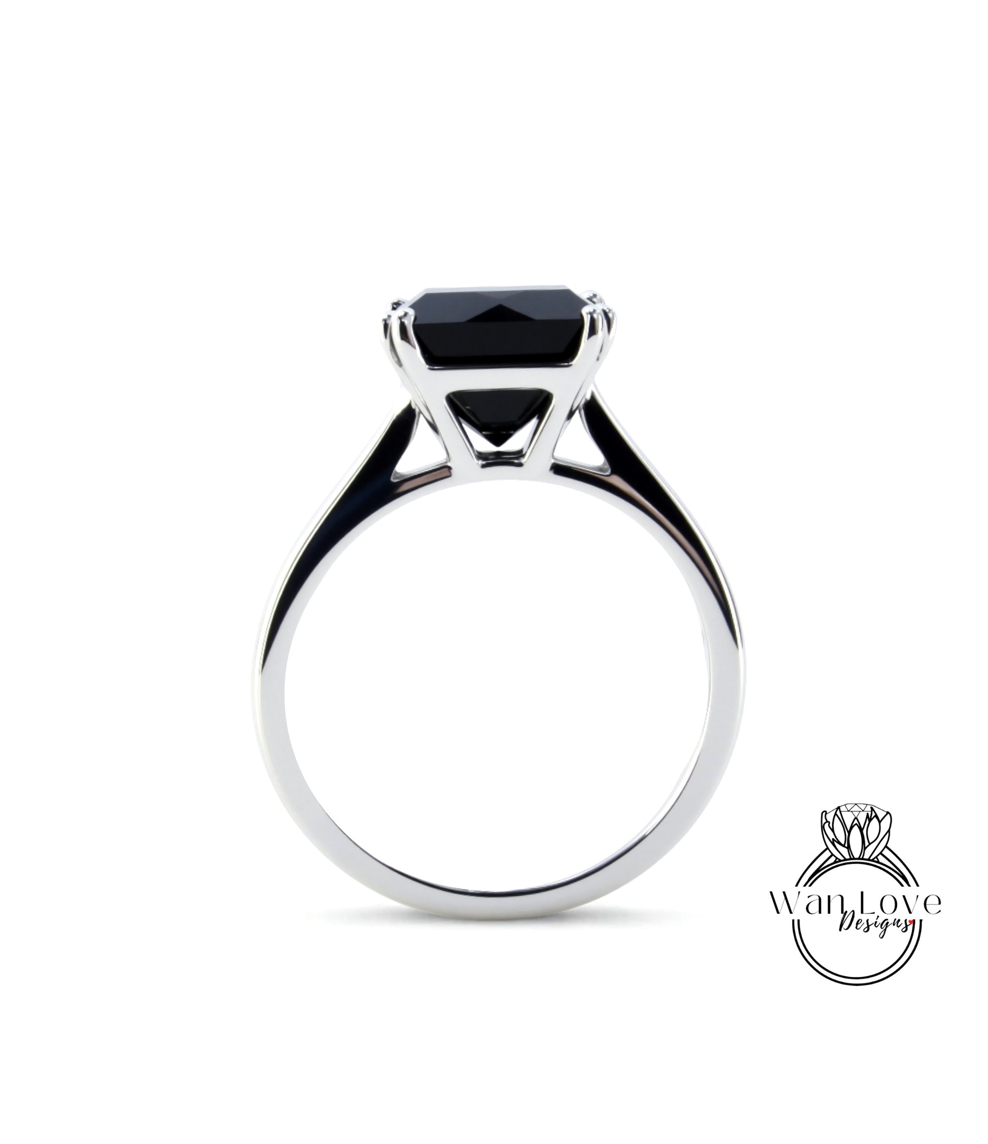 A silver ring with a large black gemstone, likely a diamond, set in the center.