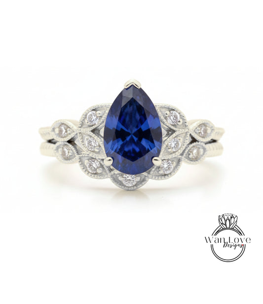 A close-up of a silver ring with a large blue gemstone, likely a sapphire, surrounded by smaller diamonds.