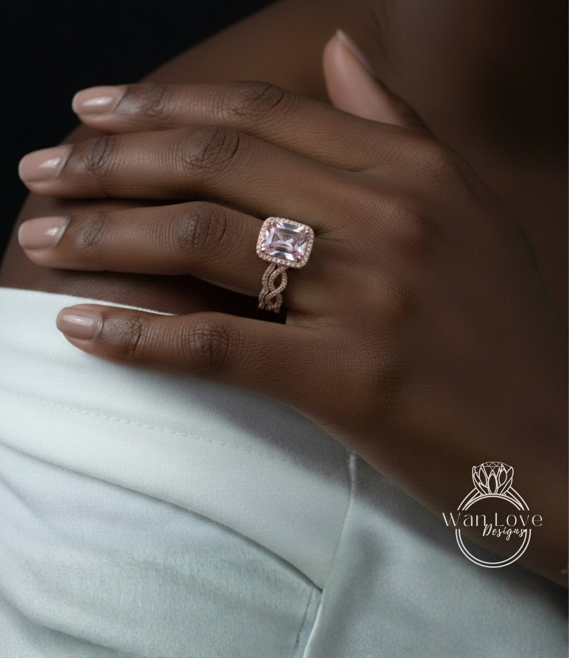 A close-up of a person's hand wearing a large, pink diamond engagement ring on the ring finger.