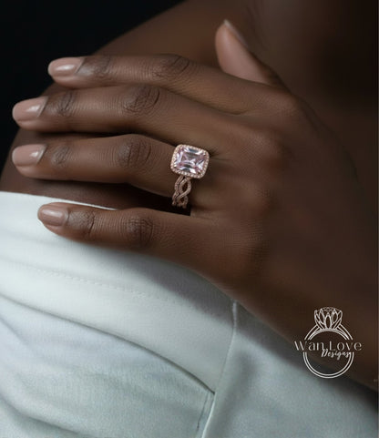 A close-up of a person's hand wearing a large, pink diamond engagement ring on the ring finger.