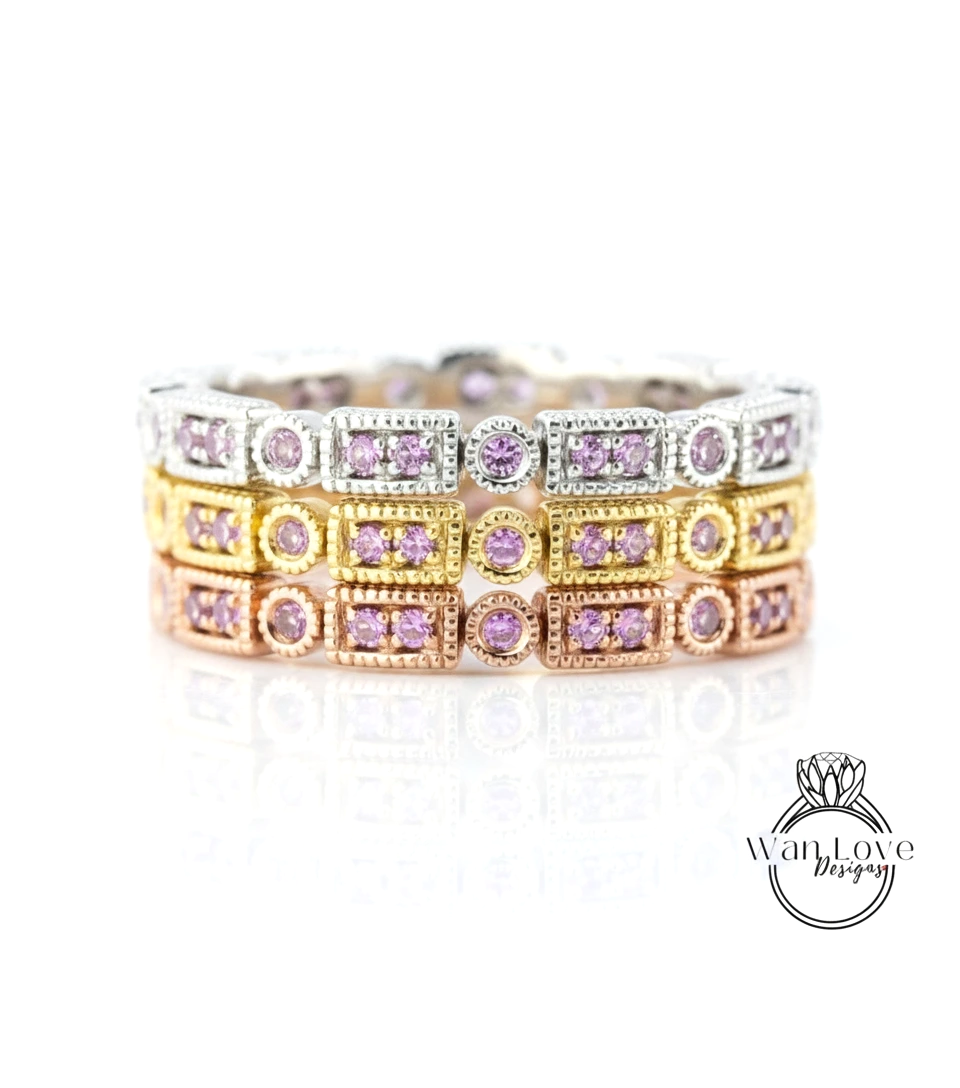 A close-up view of a ring with multiple layers of rings, each adorned with a small purple gemstone.