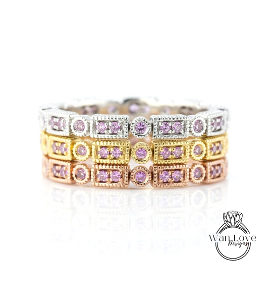 A close-up view of a ring with multiple layers of rings, each adorned with a small purple gemstone.