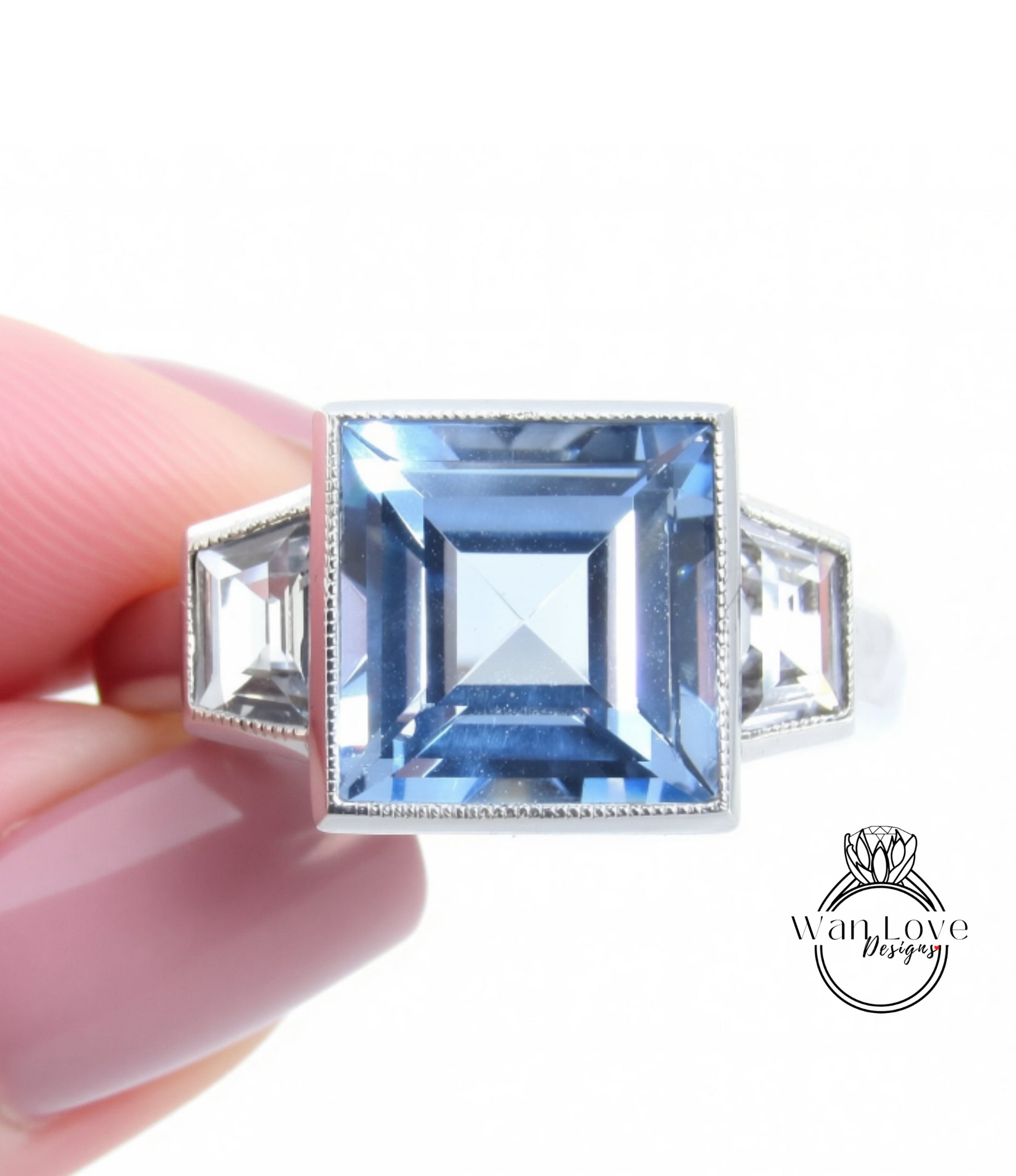 A close-up image of a person's hand holding a ring with a large blue gemstone, likely a diamond.