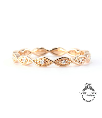 A gold ring with a twisted design and small diamonds set in the center.