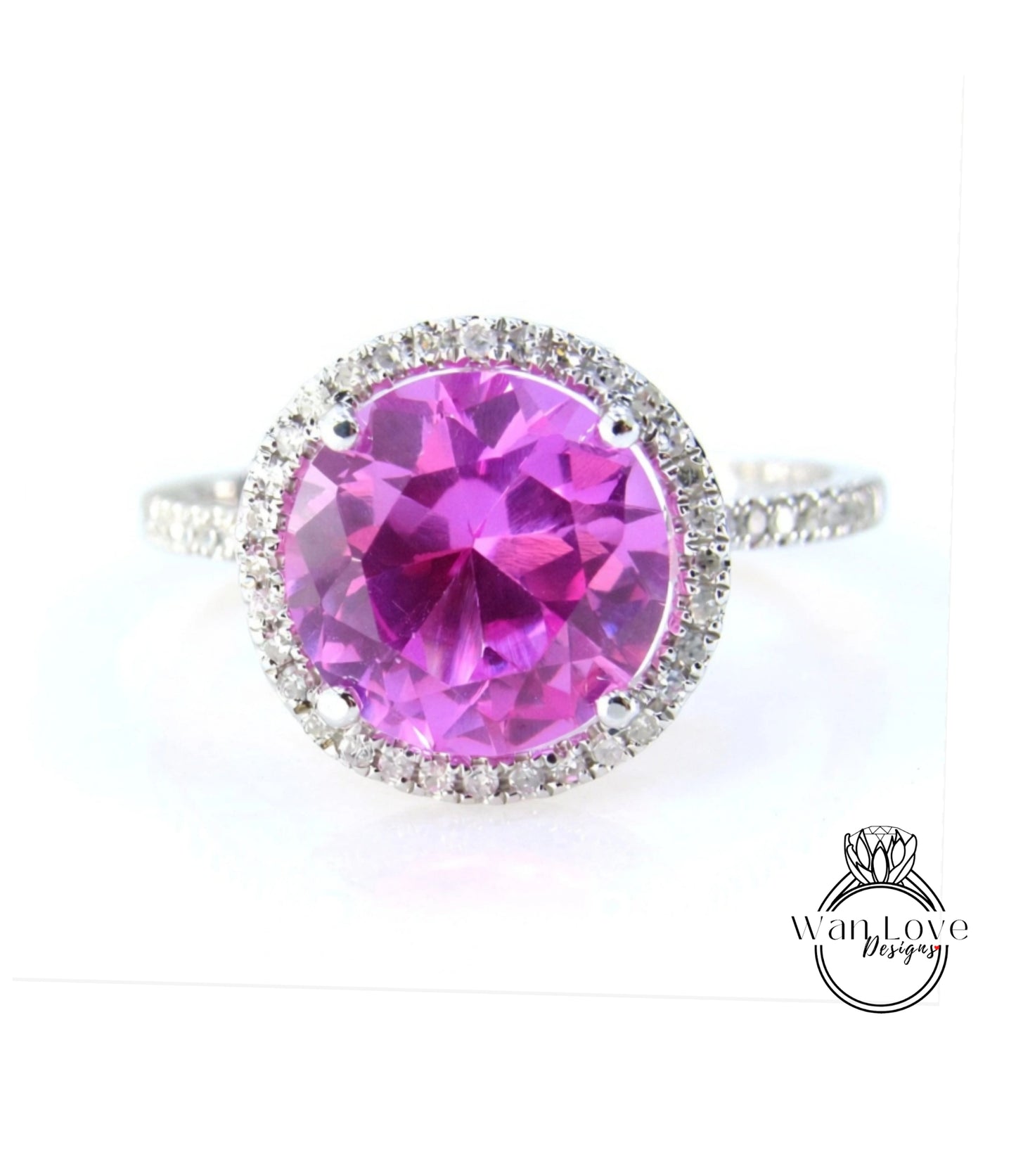 A large, round, pink gemstone ring with a halo of smaller diamonds around the center.