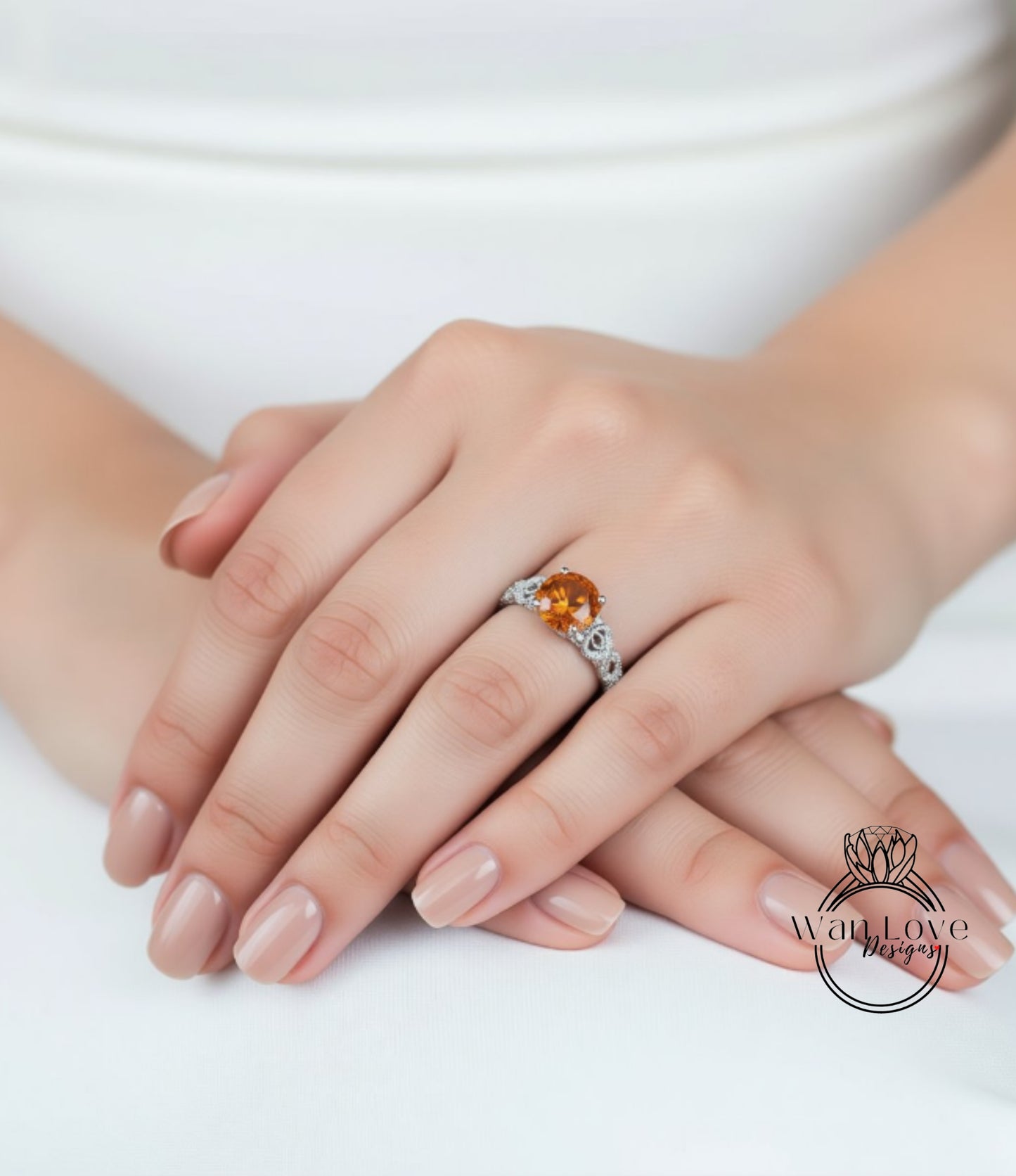 A close-up of a person's hand wearing a ring with an orange gemstone.